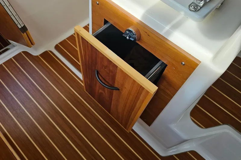 Frisky Yacht Photos Pics Open wooden drawer on Cuwater C-32-CB boat, 2022 model, with striped flooring.