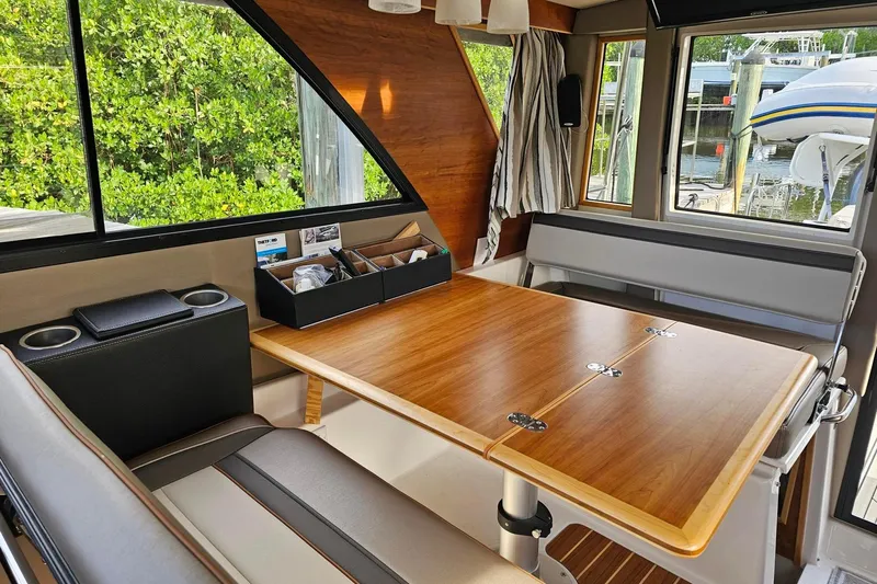 Frisky Yacht Photos Pics Interior of 2022 Cuwater C-32-CB boat with wooden table and seating area.
