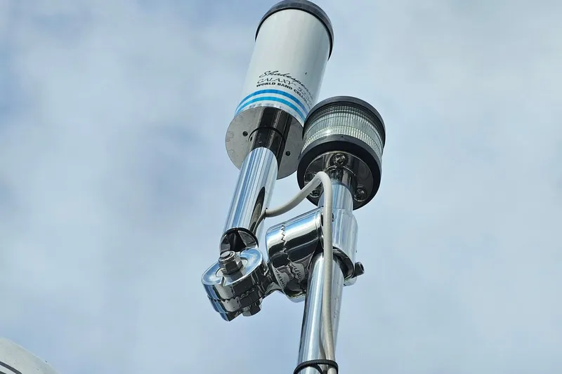 Frisky Yacht Photos Pics Antenna and light fixture on Cuwater C-32-CB, 2022 model, against cloudy sky.