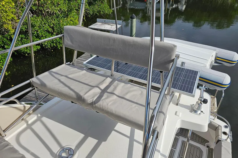 Frisky Yacht Photos Pics 2022 Cuwater C-32-CB boat with solar panels and cushioned seating by the water.