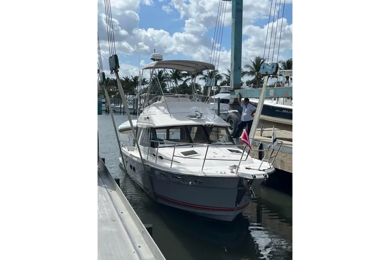 Frisky Yacht Photos Pics 2022 Cuwater C-32-CB boat docked at marina under cloudy sky.