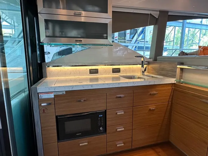 Do It All Yacht Photos Pics Modern kitchen area in a 2019 Tiara Yachts C53, featuring sleek cabinetry and built-in appliances.