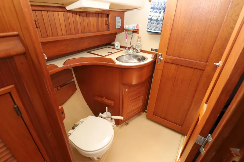 Migaloo Yacht Photos Pics 1996 Island Packet 40 yacht bathroom with wooden cabinetry and compact design.