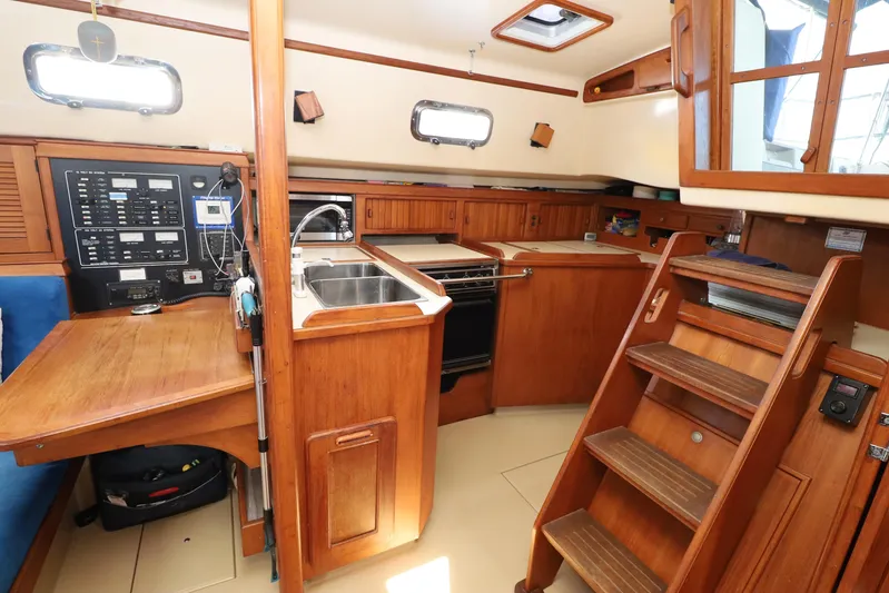 Migaloo Yacht Photos Pics Interior of a 1996 Island Packet 40 sailboat with wooden cabinetry and navigation equipment.
