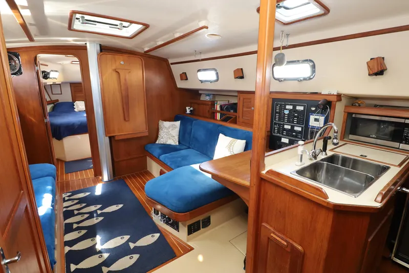 Migaloo Yacht Photos Pics Interior of 1996 Island Packet 40 yacht with blue seating and wooden finishes.