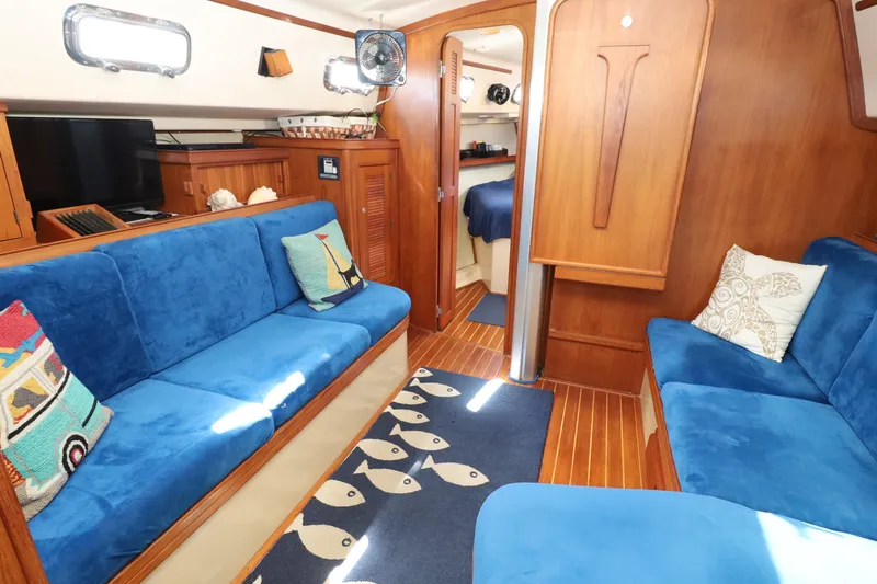 Migaloo Yacht Photos Pics Interior of a 1996 Island Packet 40 yacht with blue seating and nautical decor.