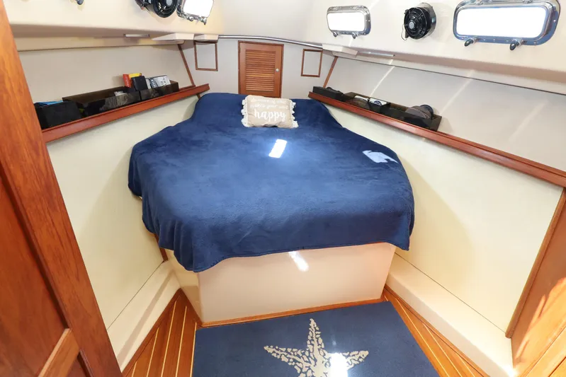 Migaloo Yacht Photos Pics Cozy cabin interior of 1996 Island Packet 40 sailboat with blue bedding and nautical decor.