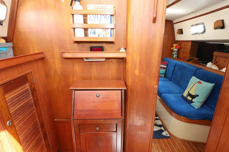 Migaloo Yacht Photos Pics Interior of 1996 Island Packet 40 sailboat with wooden cabinetry and blue seating.