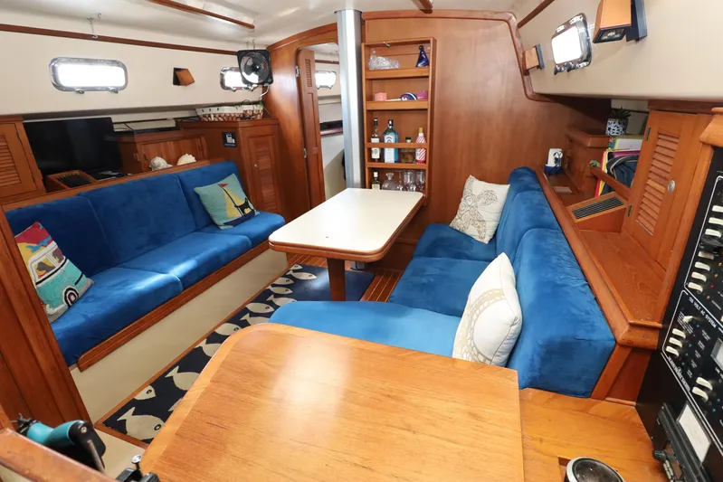 Migaloo Yacht Photos Pics Interior of 1996 Island Packet 40 sailboat with blue seating and wooden accents.
