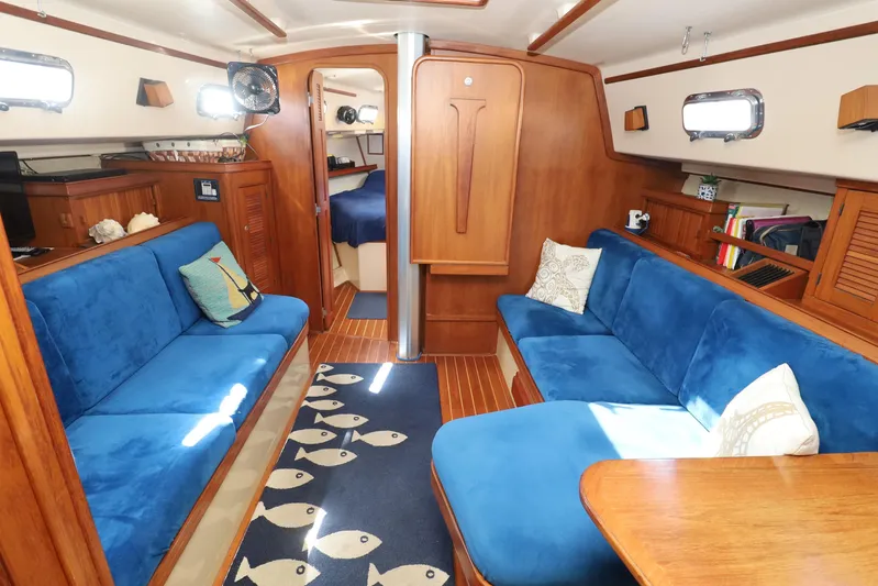 Migaloo Yacht Photos Pics Interior of 1996 Island Packet 40 sailboat with blue seating and wooden finishes.