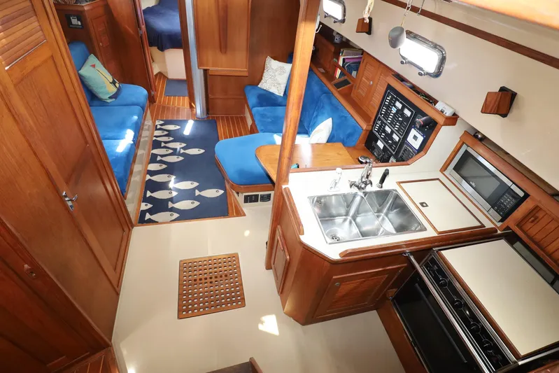 Migaloo Yacht Photos Pics Interior of a 1996 Island Packet 40 sailboat with cozy seating and modern kitchen.