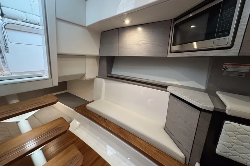  Yacht Photos Pics 2022 Tiara Yachts 43 LS interior with seating, microwave, and wooden steps.