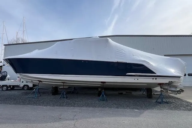  Yacht Photos Pics 2022 Tiara Yachts 43 LS covered boat on stands outside a warehouse.
