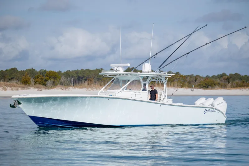 Yacht Photos Pics 2014 Yellowfin 42 Offshore boat on calm water, with fishing rods and outboard motors.