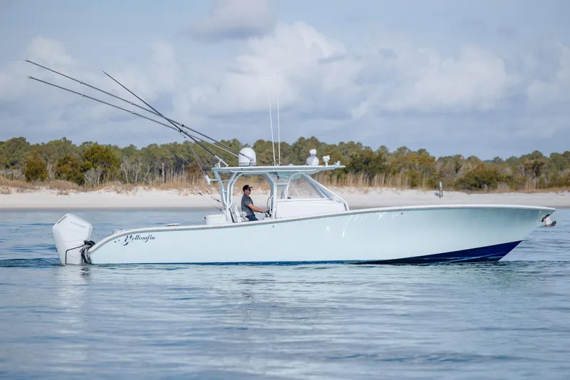  Yacht Photos Pics 2014 Yellowfin 42 Offshore boat cruising near a sandy shoreline.