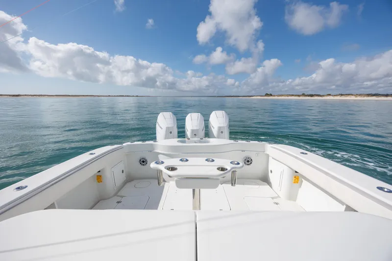  Yacht Photos Pics 2014 Yellowfin 42 Offshore boat on calm sea under blue sky with clouds.