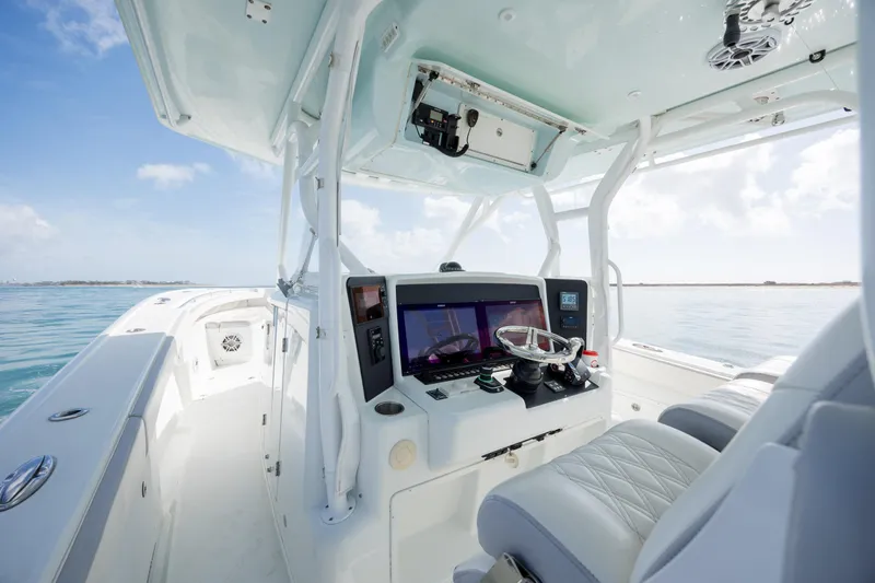  Yacht Photos Pics 2014 Yellowfin 42 Offshore boat cockpit with modern navigation equipment on calm waters.