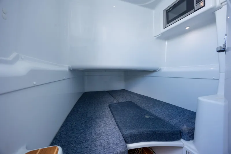  Yacht Photos Pics 2014 Yellowfin 42 Offshore cabin interior with bed and microwave, showcasing sleek design.
