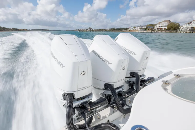  Yacht Photos Pics 2014 Yellowfin 42 Offshore boat with triple Mercury engines cruising on water.