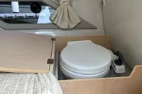Finnmaster T7 2022 boat interior with compact toilet and wooden cabinetry.