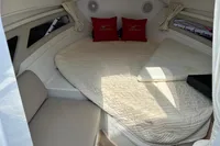 2022 Finnmaster T7 cabin interior with cozy bedding and red pillows.