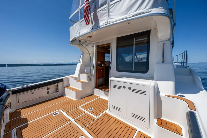 Bumber Shoot Yacht Photos Pics 2006 Silverton 42 Convertible yacht with teak deck, docked on calm water.