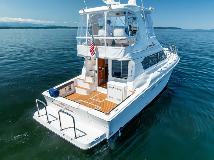 Bumber Shoot Yacht Photos Pics 2006 Silverton 42 Convertible yacht on calm water, rear view with American flag.