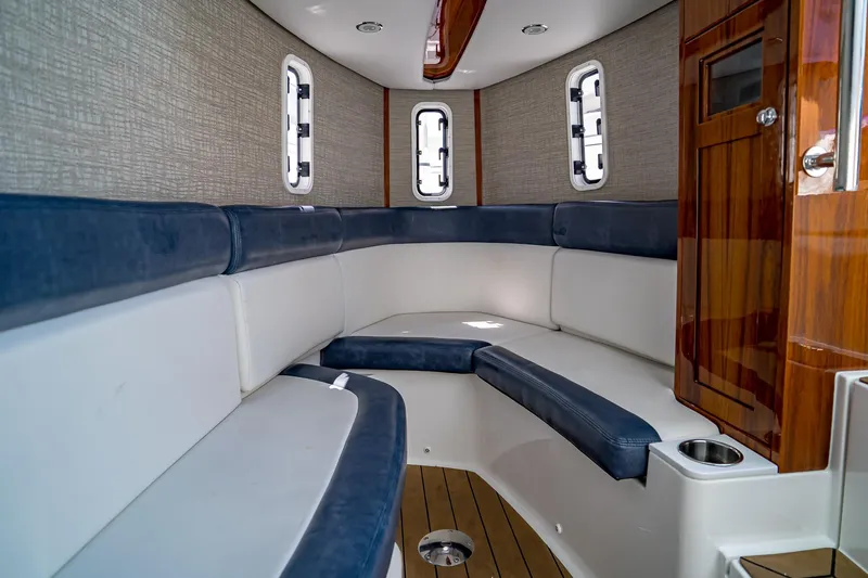  Yacht Photos Pics Interior of 2021 HCB Lujo boat with blue and white seating, wooden accents.