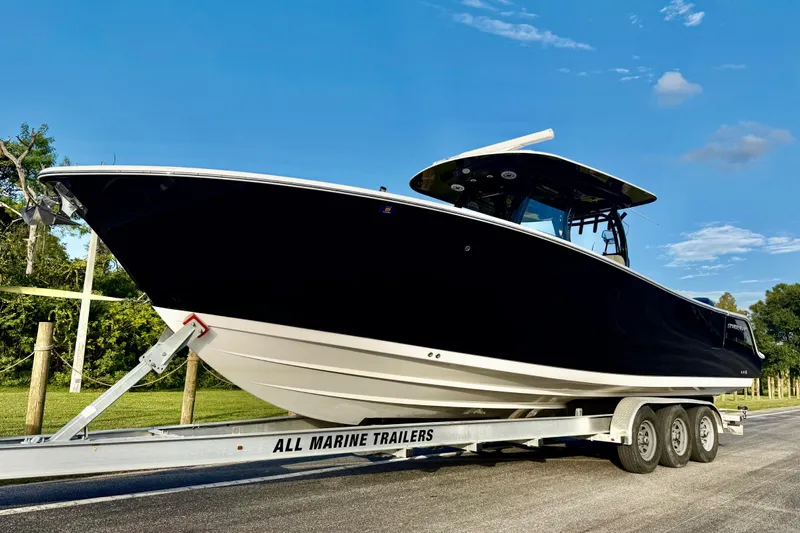 Reel Ruthless Yacht Photos Pics 2022 Sportsman Open 322 Center Console boat on trailer under clear blue sky.