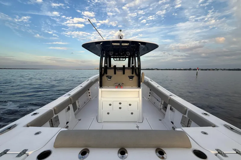 Reel Ruthless Yacht Photos Pics 2022 Sportsman Open 322 Center Console boat on calm water under a partly cloudy sky.