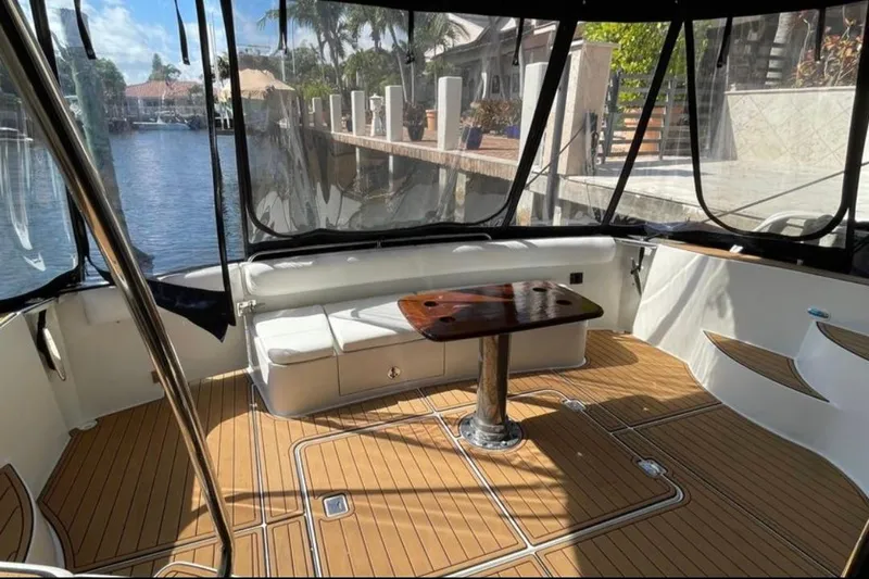  Yacht Photos Pics 2005 Carver 56 Voyager yacht interior with seating and wooden table, dockside view.