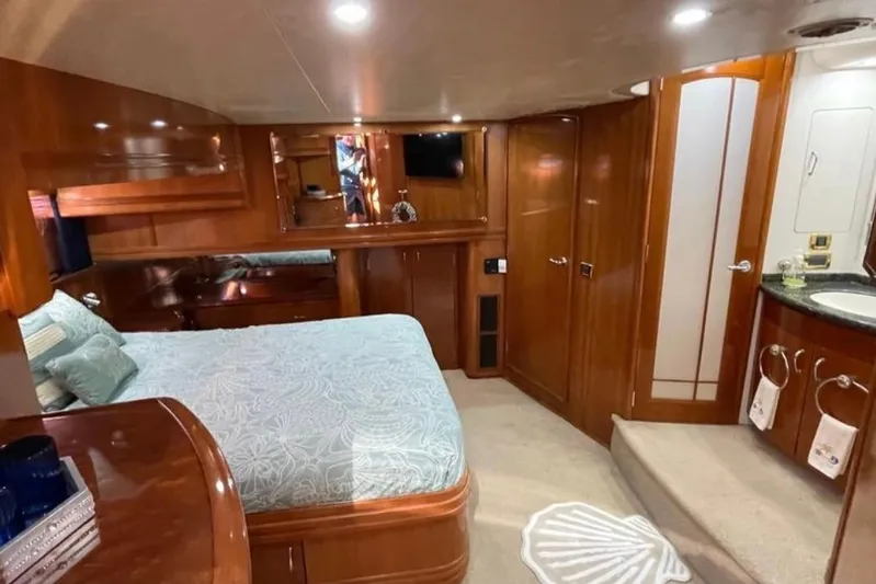  Yacht Photos Pics Luxurious 2005 Carver 56 Voyager yacht bedroom with elegant wood finishes and cozy bedding.