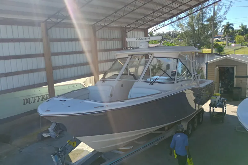 325-719 Brokerage Josh Yacht Photos Pics 2021 Grady-White Freedom 325 boat in covered storage, with sunlight streaming through.