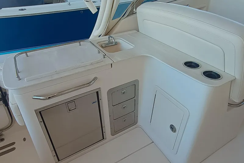 325-719 Brokerage Josh Yacht Photos Pics 2021 Grady-White Freedom 325 boat interior with sink, storage, and cup holders.