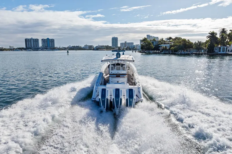 No Name Yacht Photos Pics 2023 HCB 42 Lujo boat cruising on a sunny waterfront with city skyline.