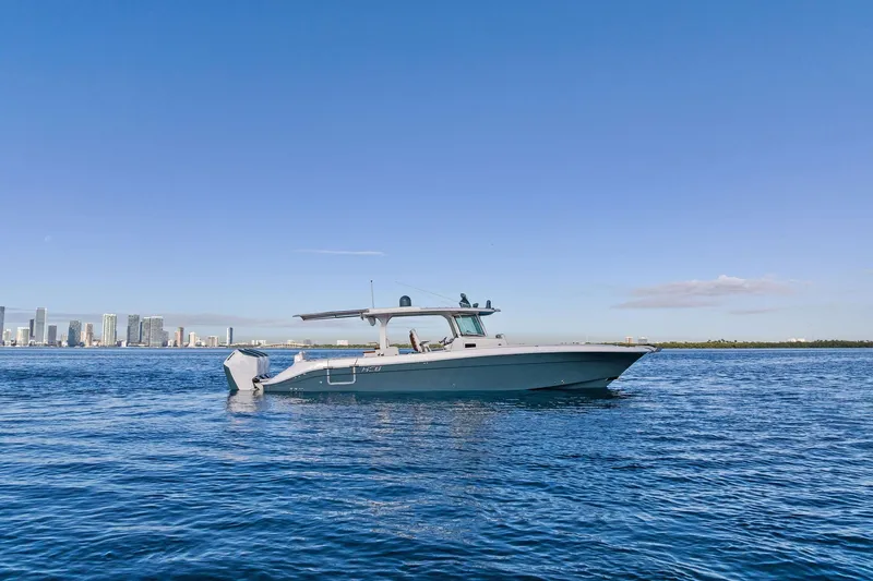 No Name Yacht Photos Pics 2023 HCB 42 Lujo boat cruising on blue water with city skyline in background.