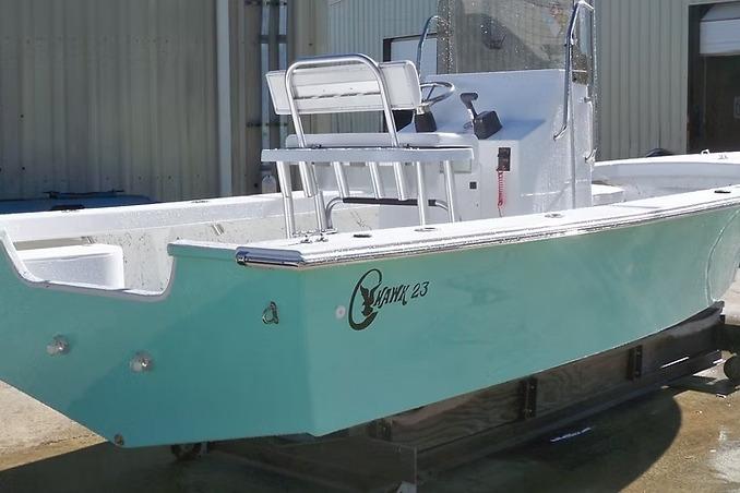 2026 C-Hawk 23 Center Console boat with turquoise hull, docked outdoors.