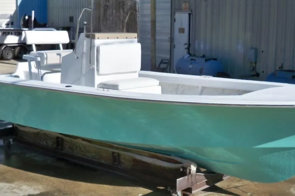 2026 C-Hawk 23 Center Console boat with teal hull, docked outdoors.