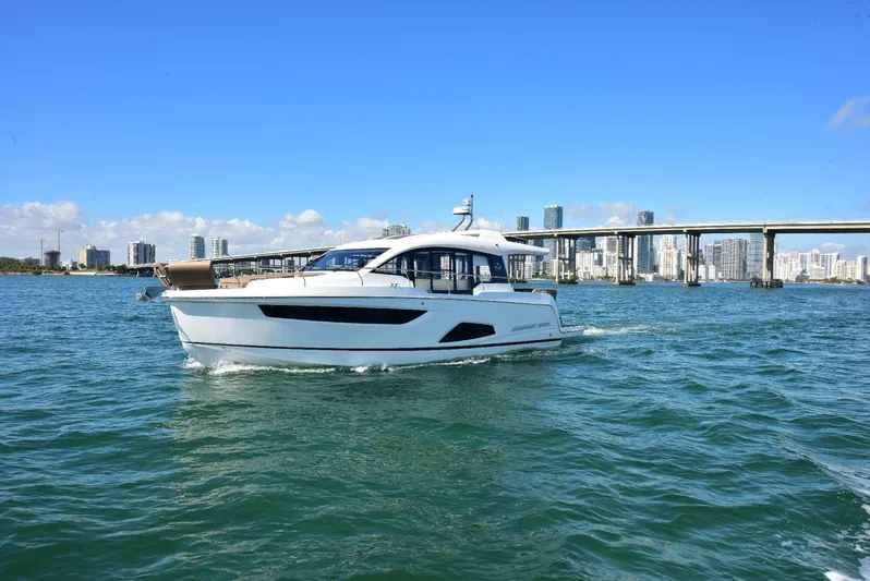  Yacht Photos Pics 2022 Sealine C430 #43 yacht cruising on open water with city skyline backdrop.