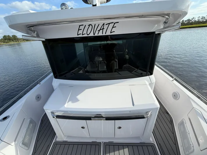  Yacht Photos Pics 2023 Axopar 37 Cross Cabin boat with sleek design on calm water.