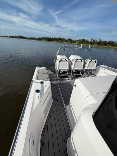  Yacht Photos Pics 2023 Axopar 37 Cross Cabin boat on calm water, featuring sleek seating and modern design.