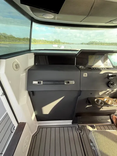  Yacht Photos Pics 2023 Axopar 37 Cross Cabin interior with modern dashboard and scenic water view.