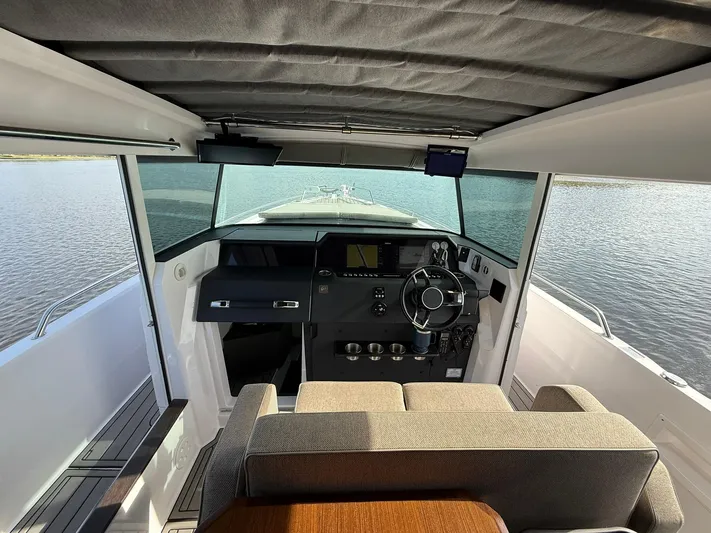  Yacht Photos Pics 2023 Axopar 37 Cross Cabin interior with modern helm and panoramic water view.
