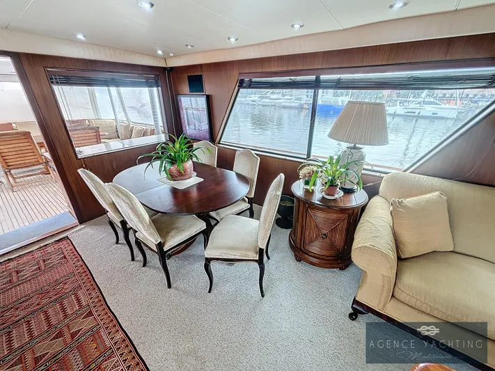  Yacht Photos Pics Luxurious interior of 1987 Hatteras 85 yacht with elegant dining area and waterfront view.