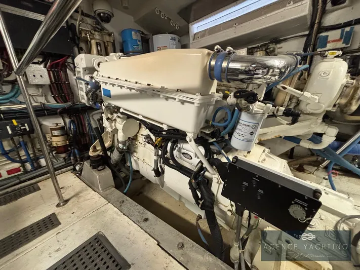  Yacht Photos Pics Engine room of a 1987 Hatteras 85 yacht, showcasing mechanical components and piping.