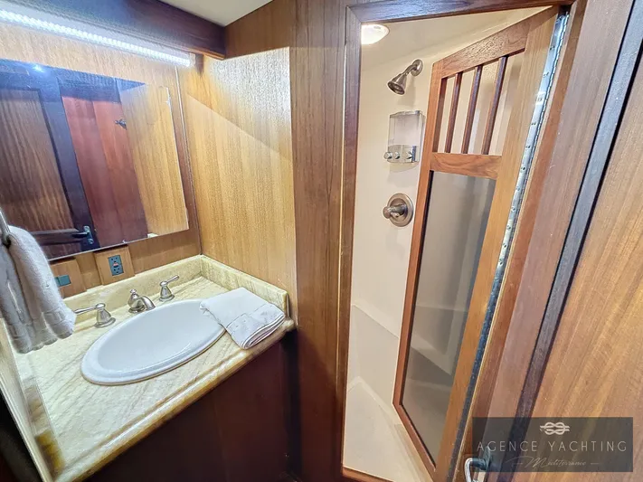  Yacht Photos Pics Bathroom interior of a 1987 Hatteras 85 yacht with wooden accents and a shower.