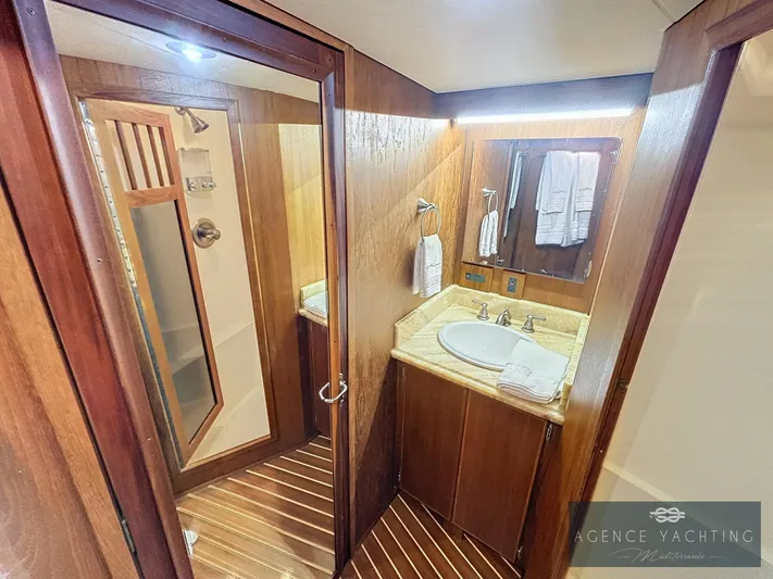  Yacht Photos Pics Luxurious bathroom on 1987 Hatteras 85 yacht with wood accents and modern fixtures.