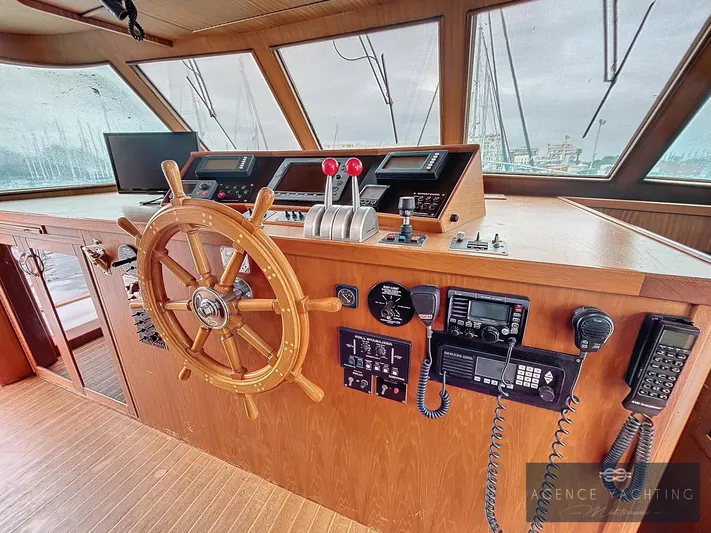  Yacht Photos Pics Helm of 1987 Hatteras 85 yacht with wooden wheel and navigation equipment.