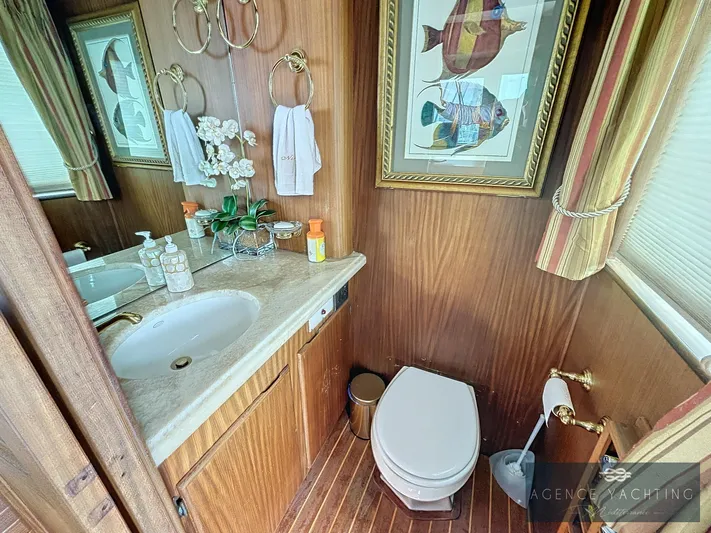  Yacht Photos Pics Bathroom interior of 1987 Hatteras 85 yacht with wood paneling and nautical decor.
