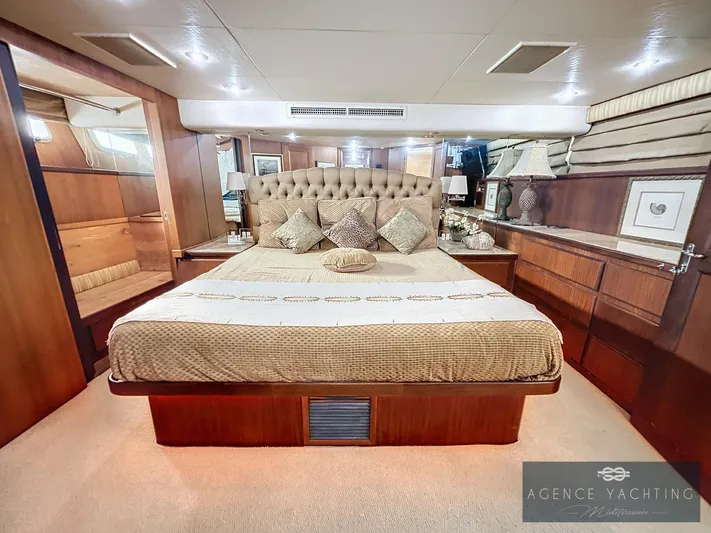  Yacht Photos Pics Luxurious bedroom interior of a 1987 Hatteras 85 yacht with elegant wood finishes.